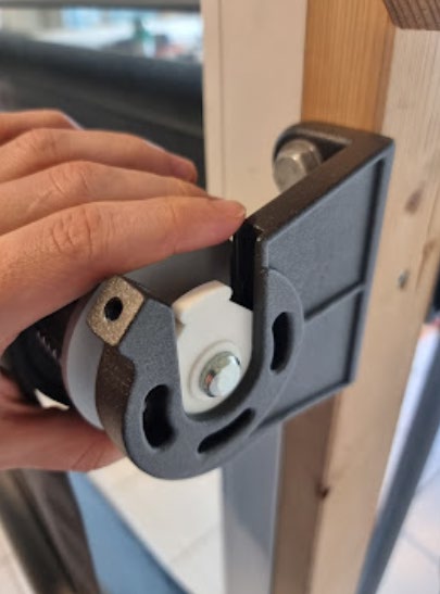 Rullen løftes på plass i braketten på motstående side