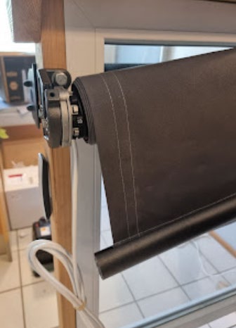 Rullen løftes opp og tres inn i braketten på motorsiden