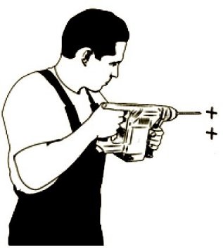 Person forborrer hull i veggen med drill