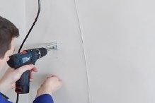 Første styrewire-brakett festes til veggen med drill