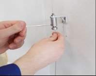 Øvre skrue løsnes forsiktig til bunnen av wirestrammeren løsner