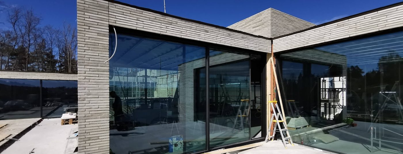 Terrassen på huset på Nesøya med glassvegger fra gulv til tak og teglkledning