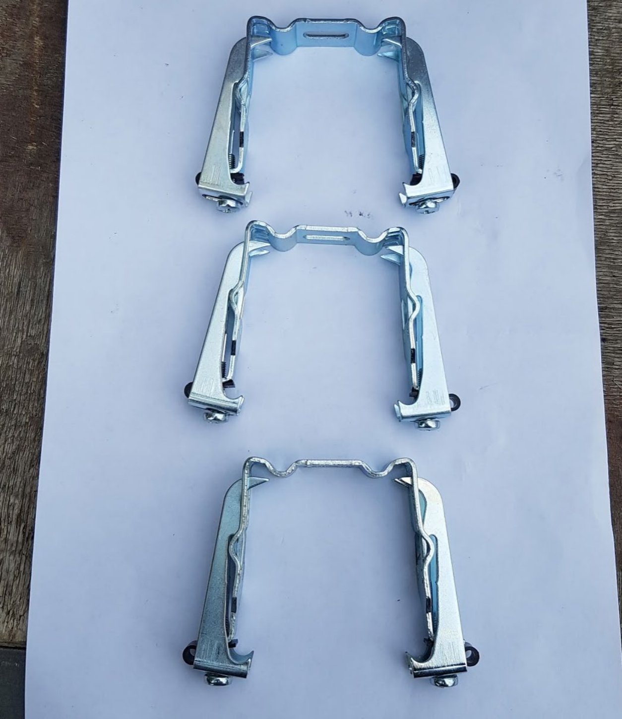 Tre braketter som holder skinne med motor og lameller
